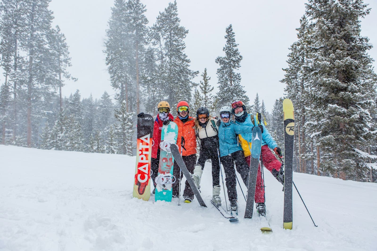Gruppe von Skifahrern und Snowboardern steht gemeinsam lachend im Schnee